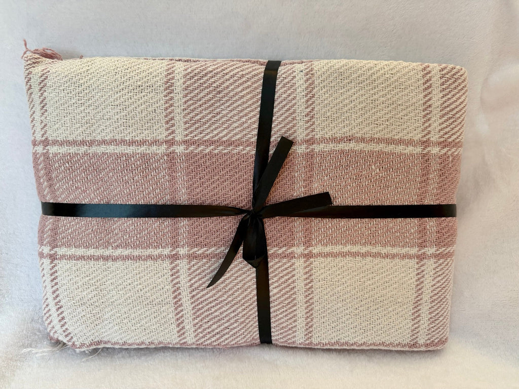 Pink and cream checked throw tied with black ribbon
