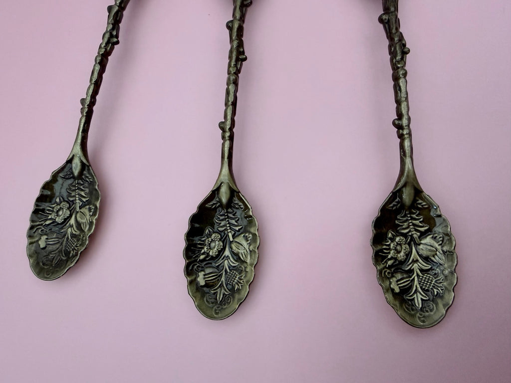 Ornate botanical detail on ritual spoons