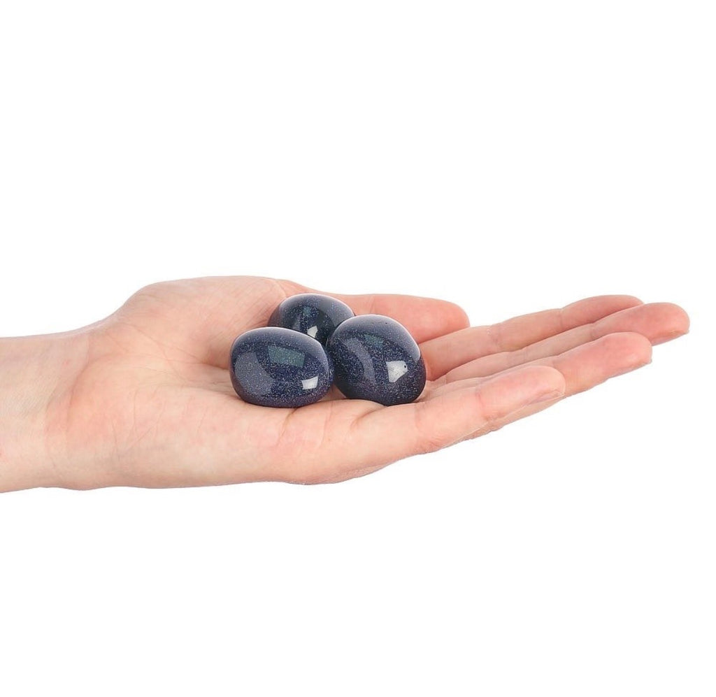 Blue Goldstone tumblestones shown in hand for scale