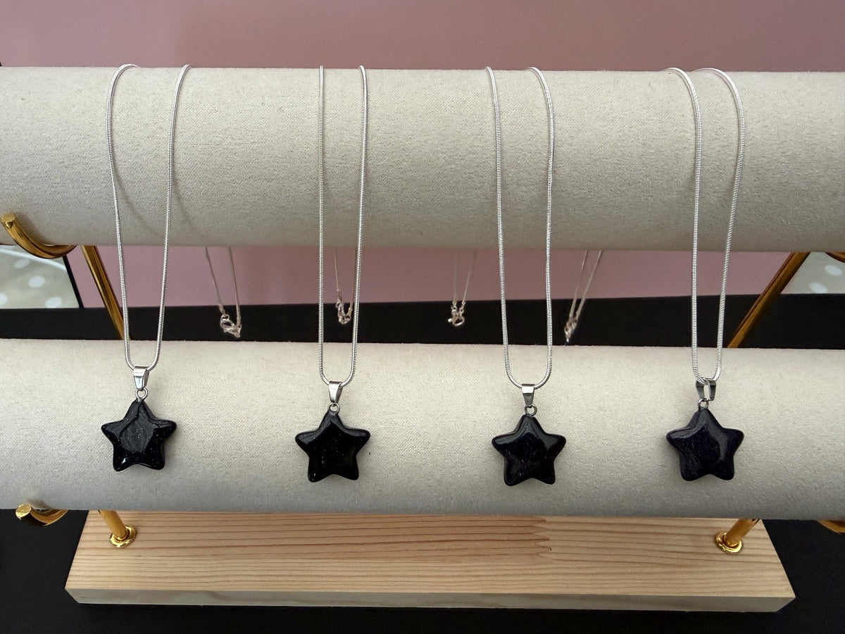 Four blue goldstone star necklaces on jewellery display