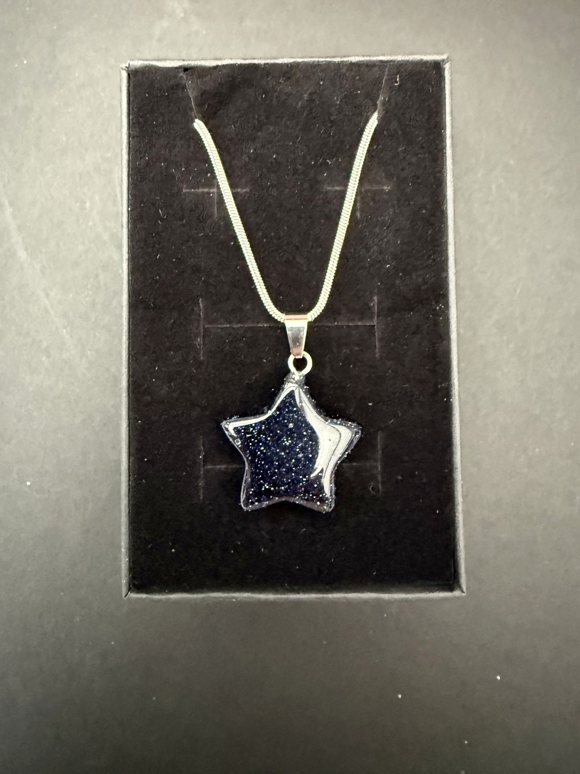 Blue goldstone star necklace on presentation card